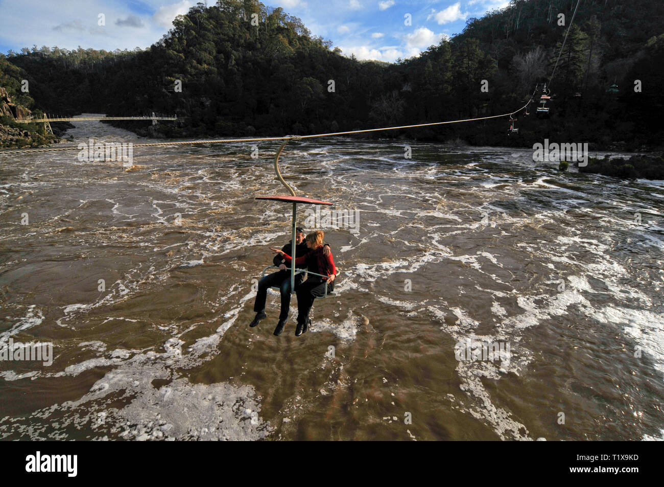 Deux personnes sur un télésiège, suspendu au-dessus de la Rivière Tamar inondées à Launceston, en Tasmanie, Australie. Banque D'Images