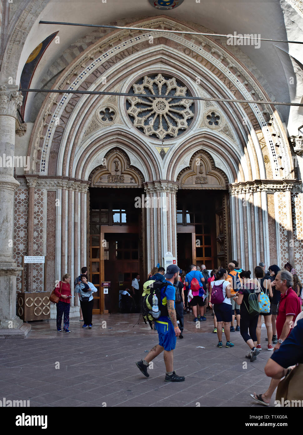 Assisi Ombrie Italia, Italie. Le portail d'entrée de la Basilique inférieure de Saint François (Basilica Inferiore di San Francesco d'assise), les pèlerins Banque D'Images