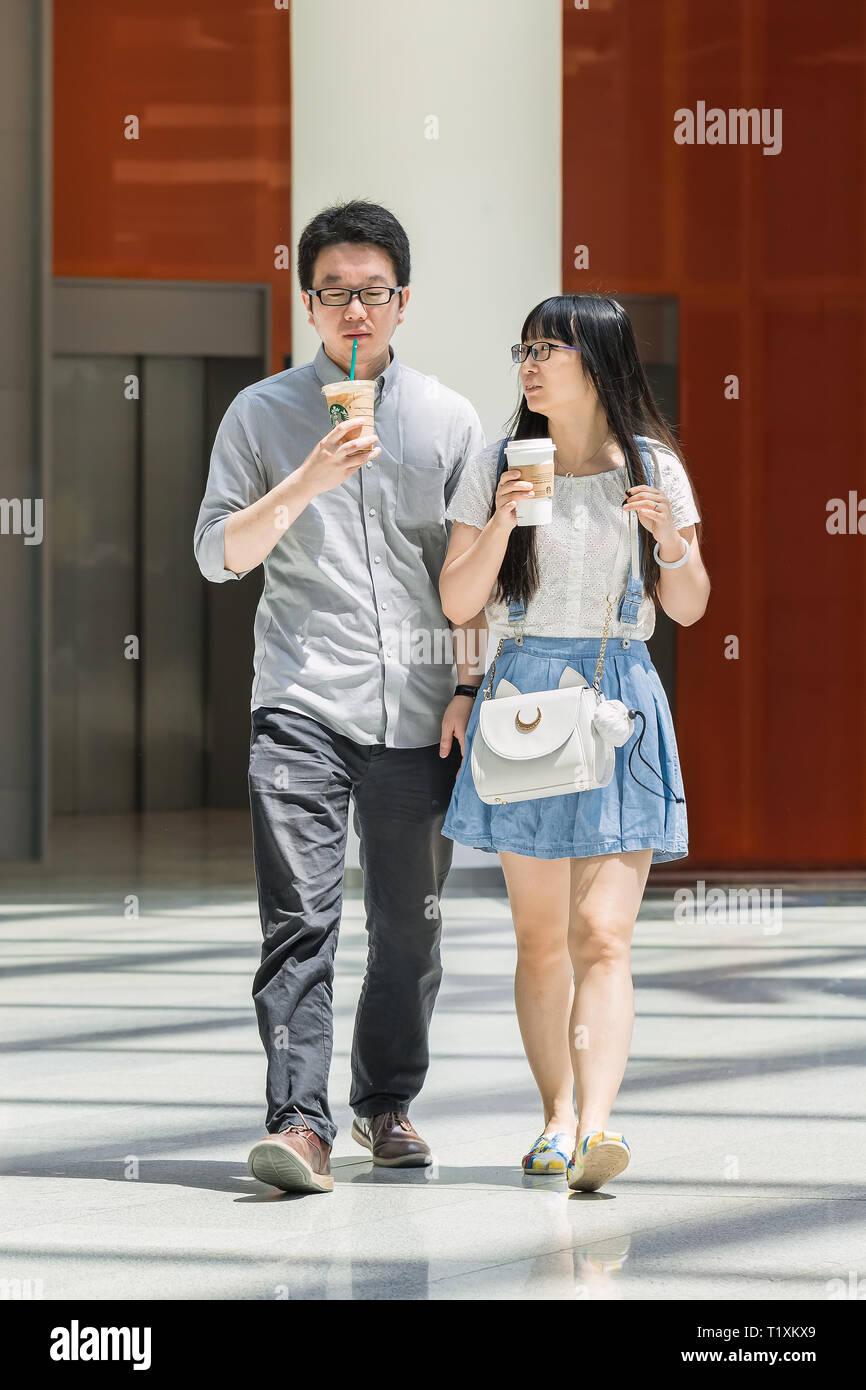 Jeune couple chinois avec du café Starbucks. En janvier 2019, Starbucks a 3 521 magasins en Chine, ce qui en fait le deuxième plus important marché après nous. Banque D'Images