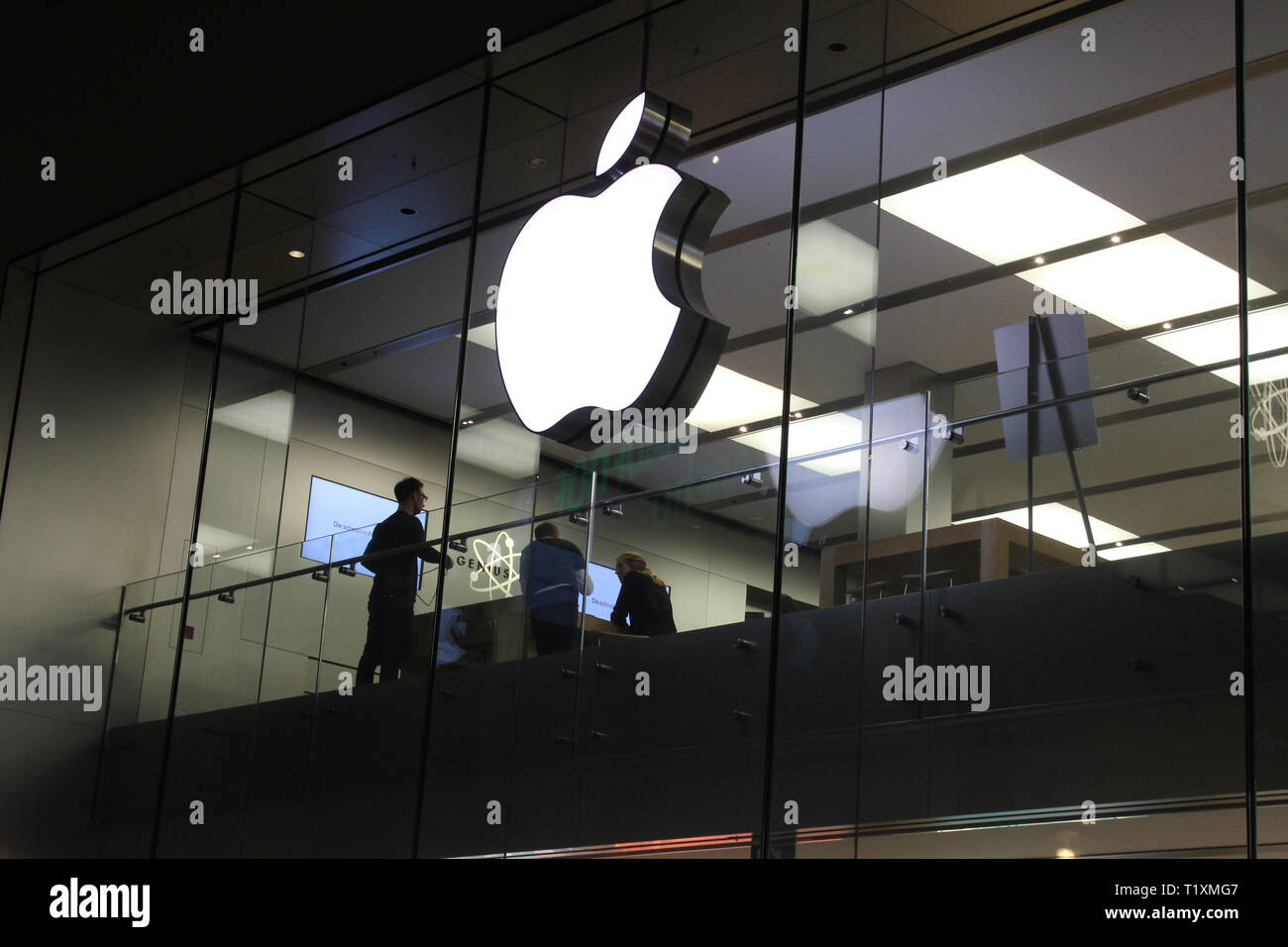 Façade en verre d'Apple Store avec logo de pomme la nuit.Les clients et le personnel à l'intérieur du magasin de pommes.Par prise de vue de nuit. Banque D'Images
