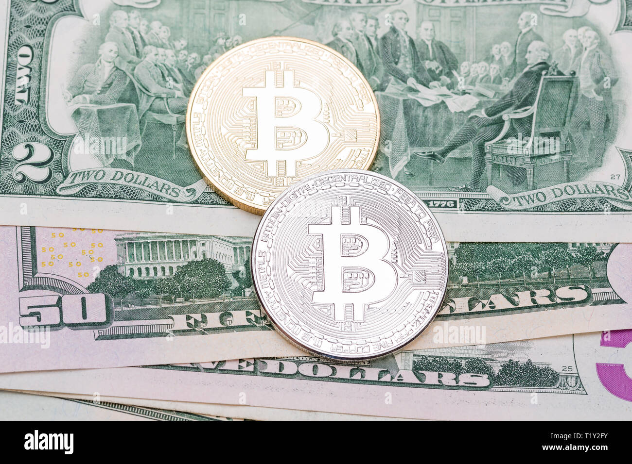 Bitcoin d'or et d'argent sur nous des billets de banque. Banque D'Images