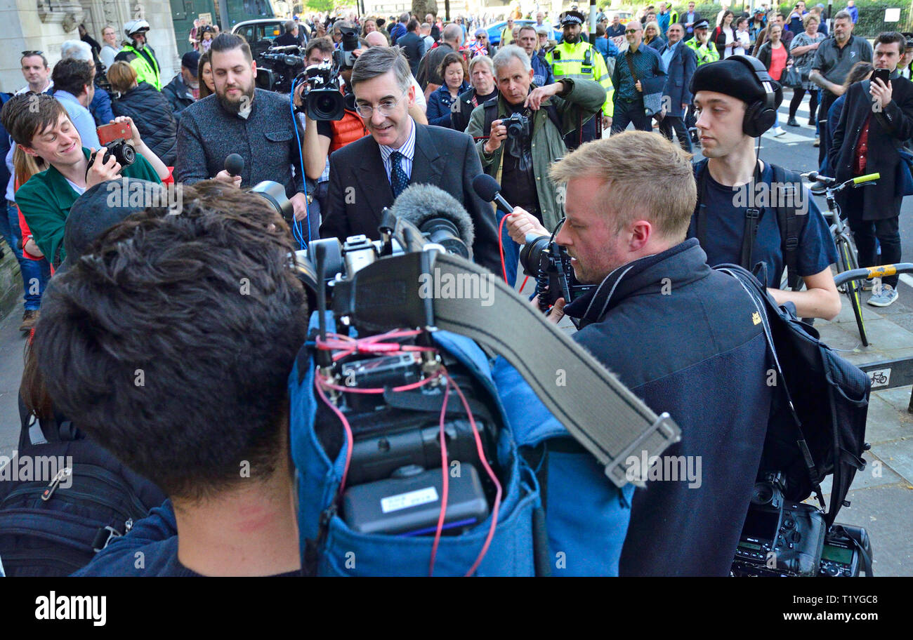 Londres, Royaume-Uni. 29 mars 2019. Jacob Rees-Mogg MP est accompagnée de sa courte promenade accueil par Brexit protestataires et les médias Crédit : PjrFoto/Alamy Live News Banque D'Images