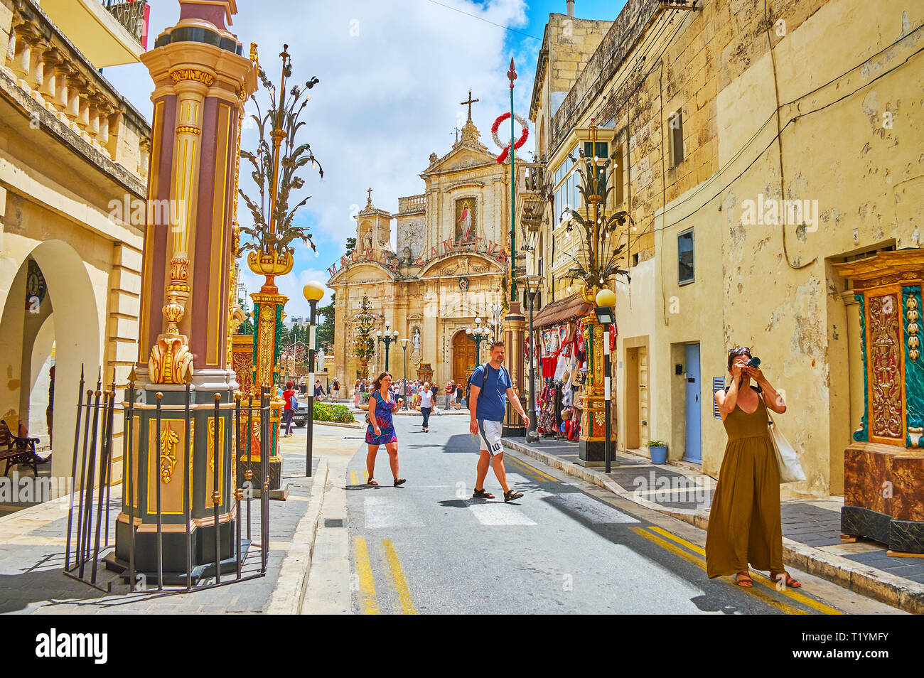 RABAT, MALTE - 16 juin 2018 : rue étroite de la vieille ville, bordée de demeures historiques, décoré de colonnes de la fête de la ville, la façade de St Paul chur Banque D'Images