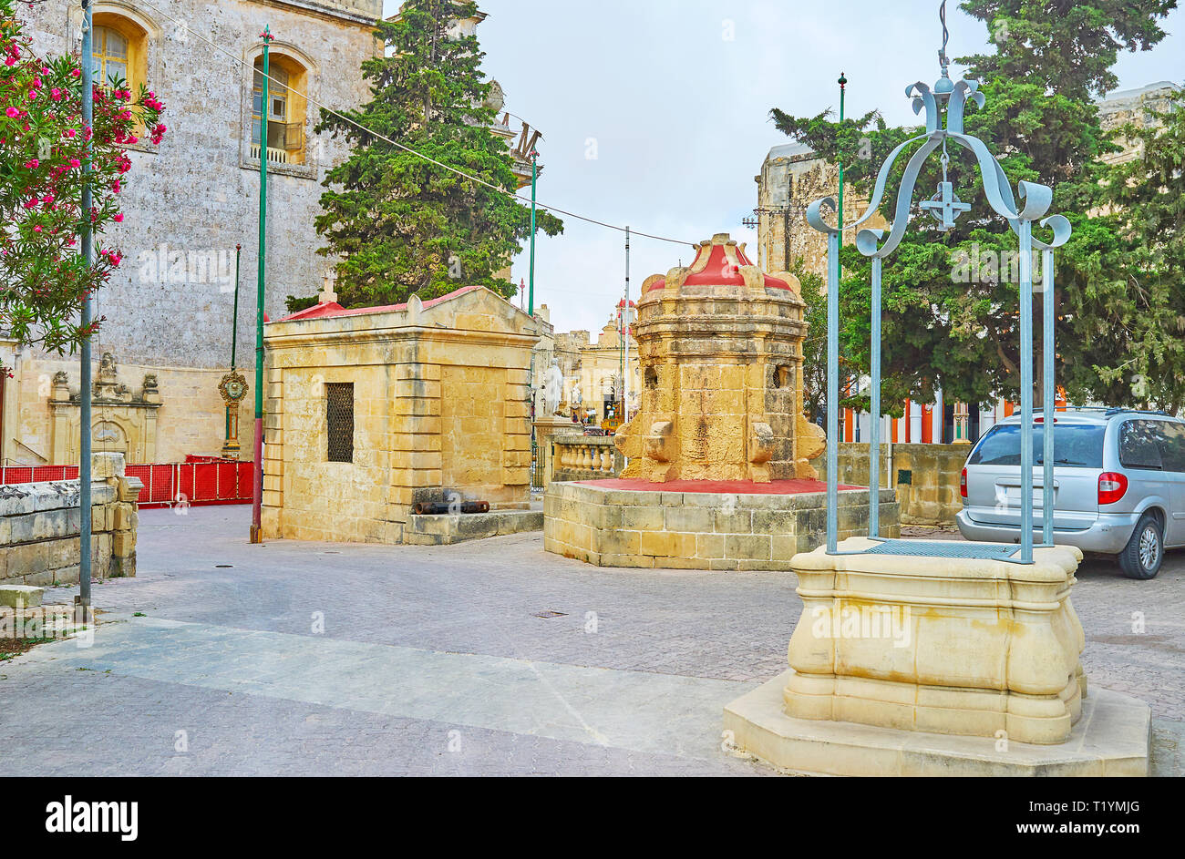 Le jardin pittoresque à St Paul église avec ancien puits et petite crypte sur l'arrière-plan, Rabat, Malte. Banque D'Images