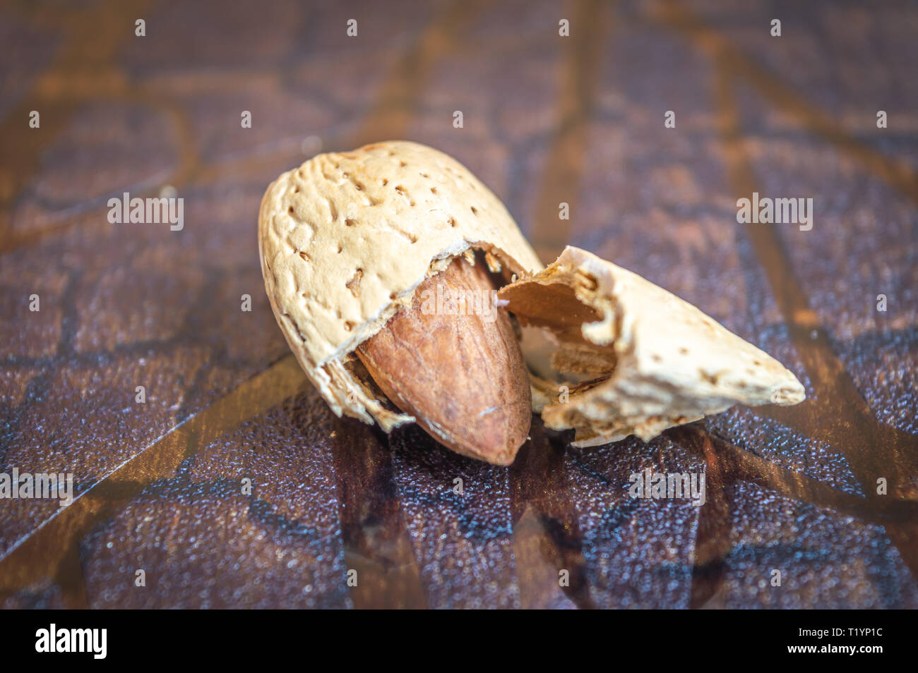 Le noyau d'Amande fruits amande amande cassée de la brown shell sur un fond en bois brun Banque D'Images