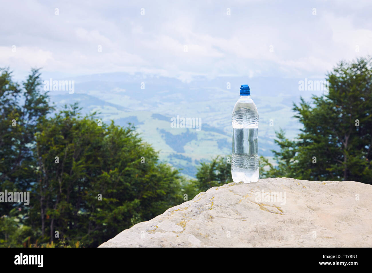 Un flacon de l'eau potable en bouteille en plastique sur la montagne paysage de montagne contre Banque D'Images