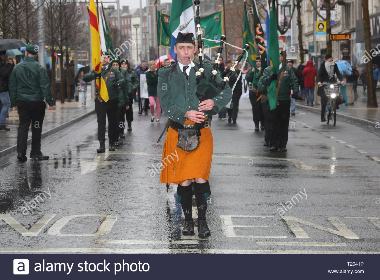 Un cornemuseur soliste dirige un mars républicaine en l'honneur de l'augmentation de 1916 à travers les rues de Dublin à Pâques. Banque D'Images