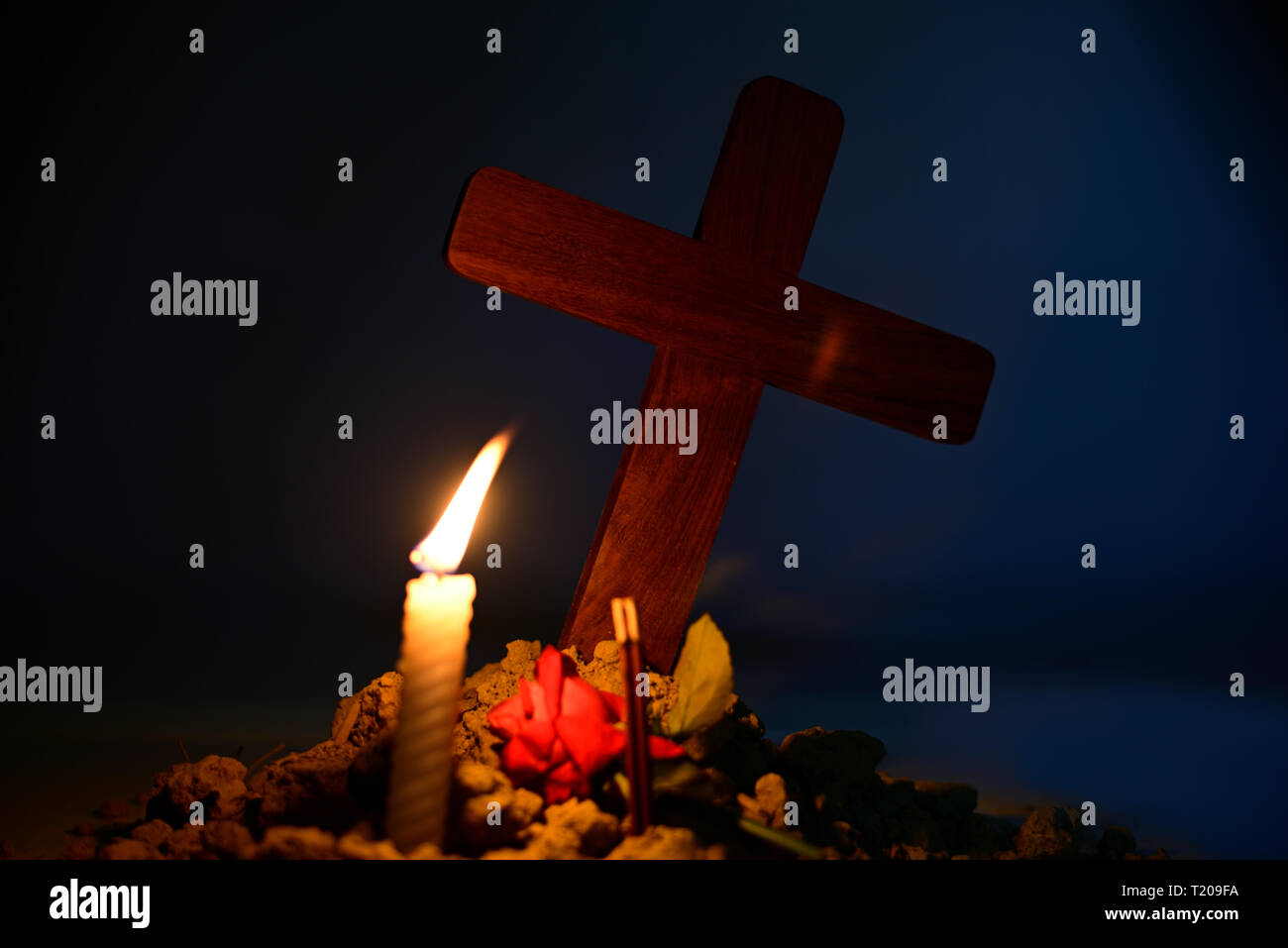 Qui rend l'âme humaine. Donner une bougie et rose sous Jésus croix dans le cimetière de lune. Banque D'Images