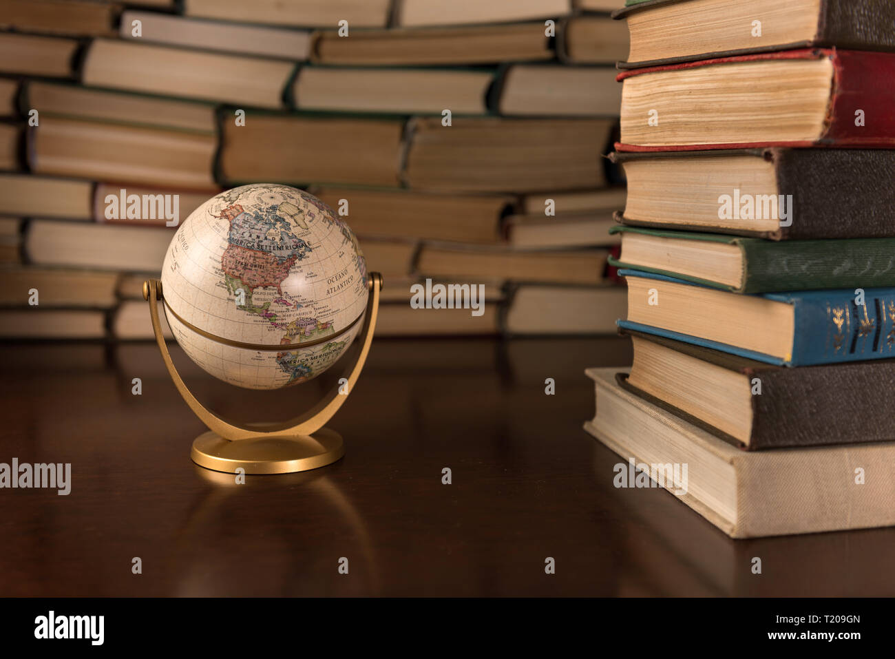 Globe et beaucoup de livres sur une table en bois Banque D'Images