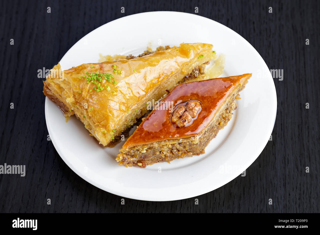 Dessert traditionnel arabe baklava aux noix et à la cardamome, sur une table en bois. Des baklava aux noix et miel Banque D'Images