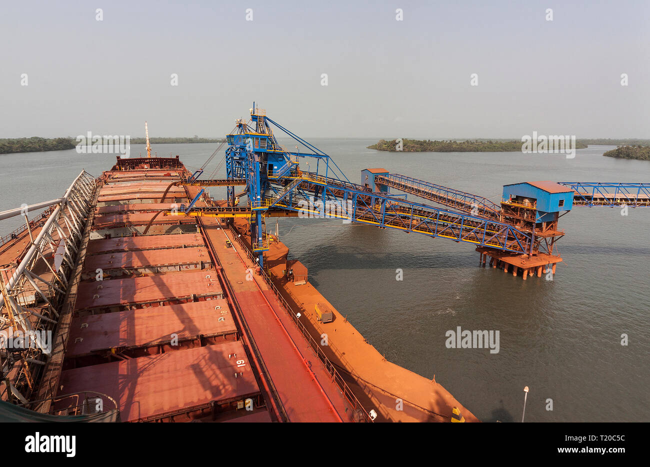 Opérations portuaires pour la gestion et le transport de minerai de fer. Le chargement est titulaire des transhipper bateau avec ore via 2 chargeurs de navires sur jetty avant le transport à l'OGV Banque D'Images