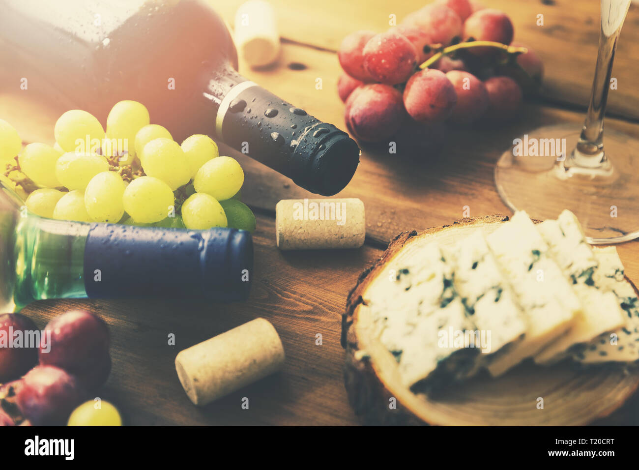 Les bouteilles de vin et fromage sur le raisin de table en bois ancien Banque D'Images