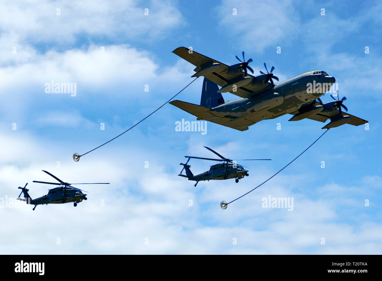 C-130 Hercules du ravitaillement en vol de deux hélicoptères Blackhawk Banque D'Images