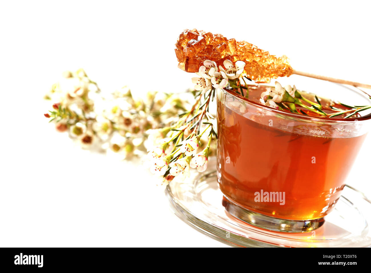 Miel de fleurs joliment décorées dans un verre. Sur le dessus il y a un sucre candy stick. Banque D'Images