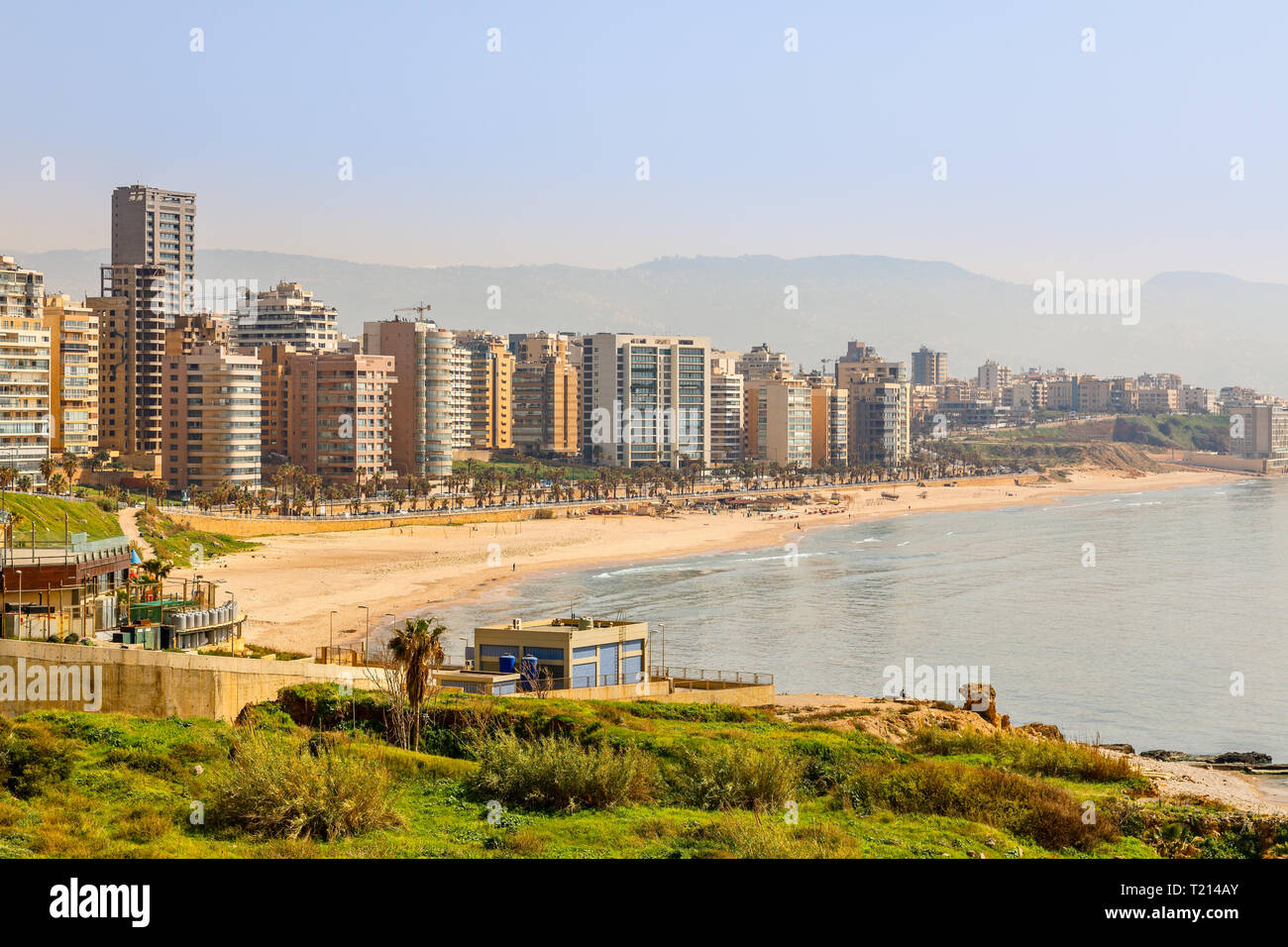 Des bâtiments et des tours du centre-ville avec la route, sable et mer au premier plan, Beyrouth, Liban Banque D'Images