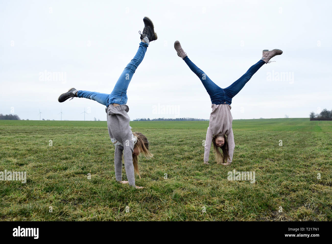 Deux filles doing handstand on a meadow Banque D'Images