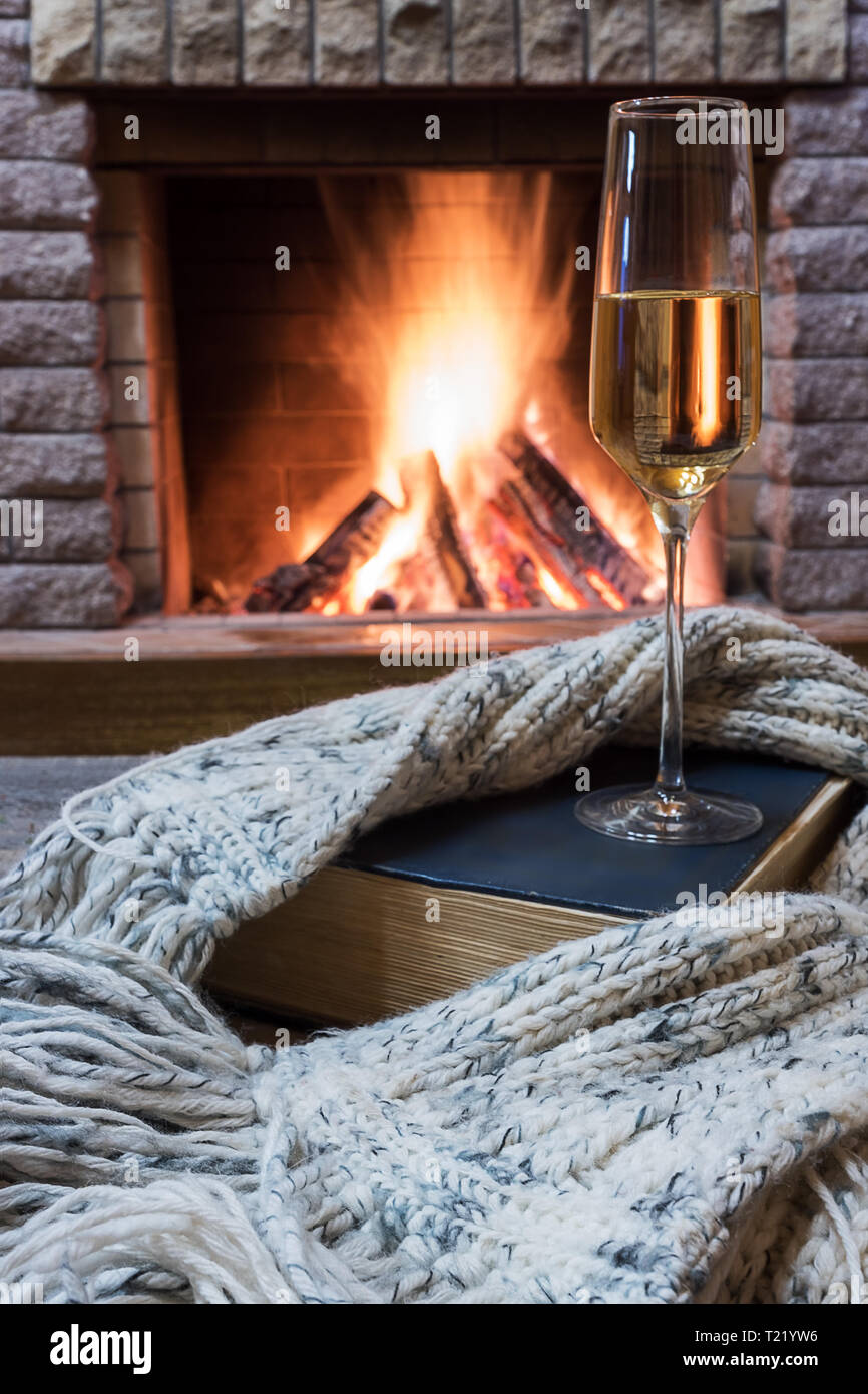 Verre de vin, réserver au chaud et écharpe de laine près de cheminée  confortable dans maison de vacances d'hiver Photo Stock - Alamy