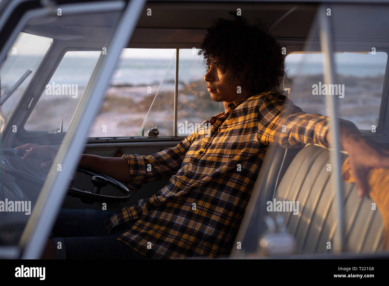 De race mixte détendue homme conduisant un camping-car on beach Banque D'Images