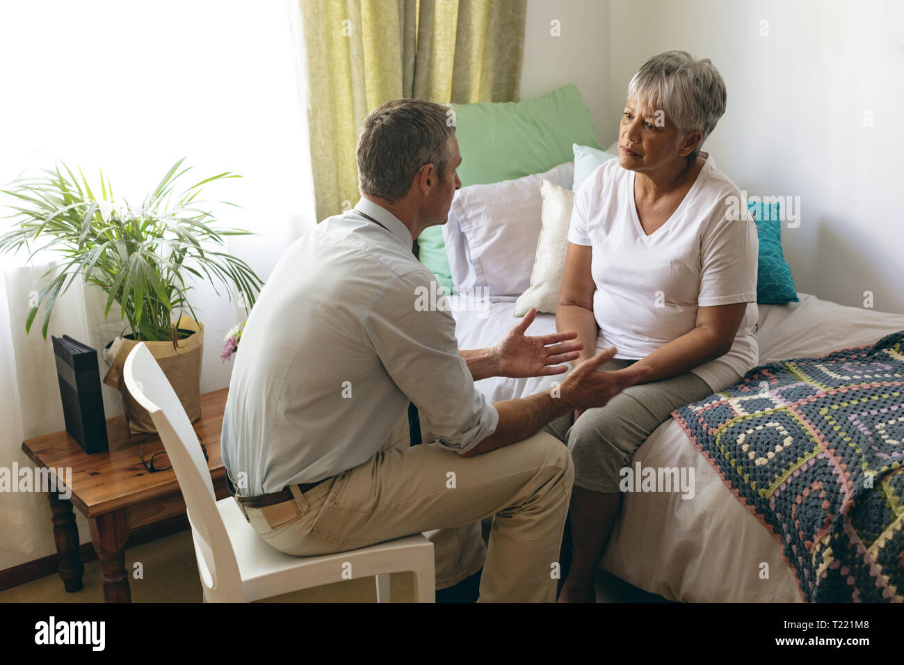 Médecin homme d'interagir avec les patients de sexe féminin à maison de retraite Banque D'Images