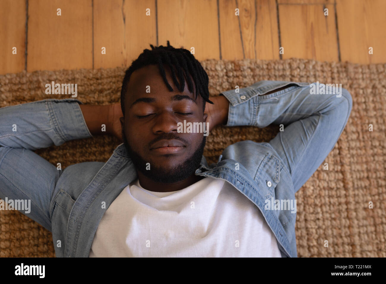 Handsome man lying on floor at home Banque D'Images
