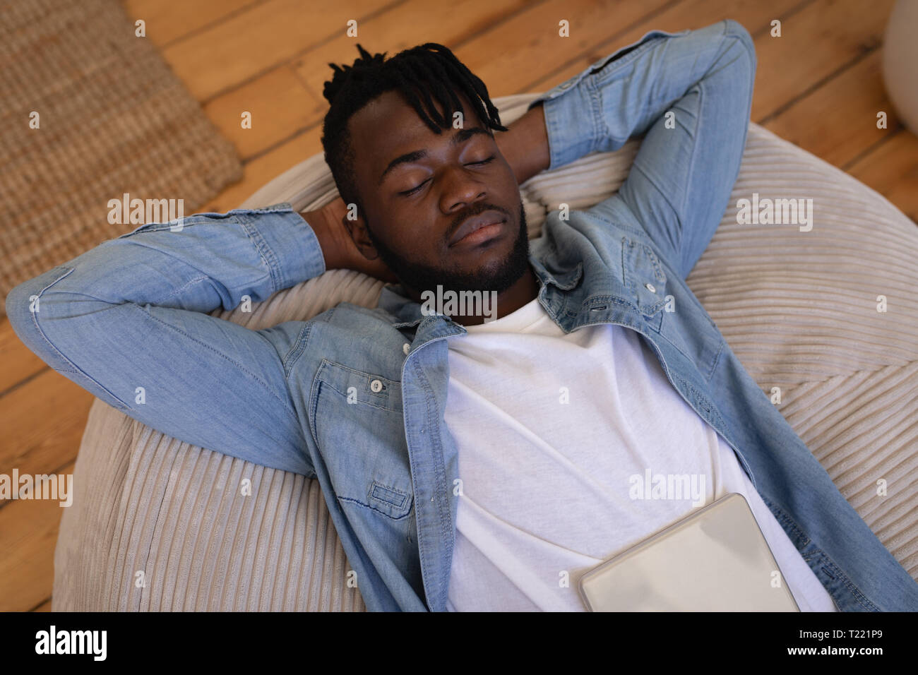 Handsome man lying on floor at home Banque D'Images