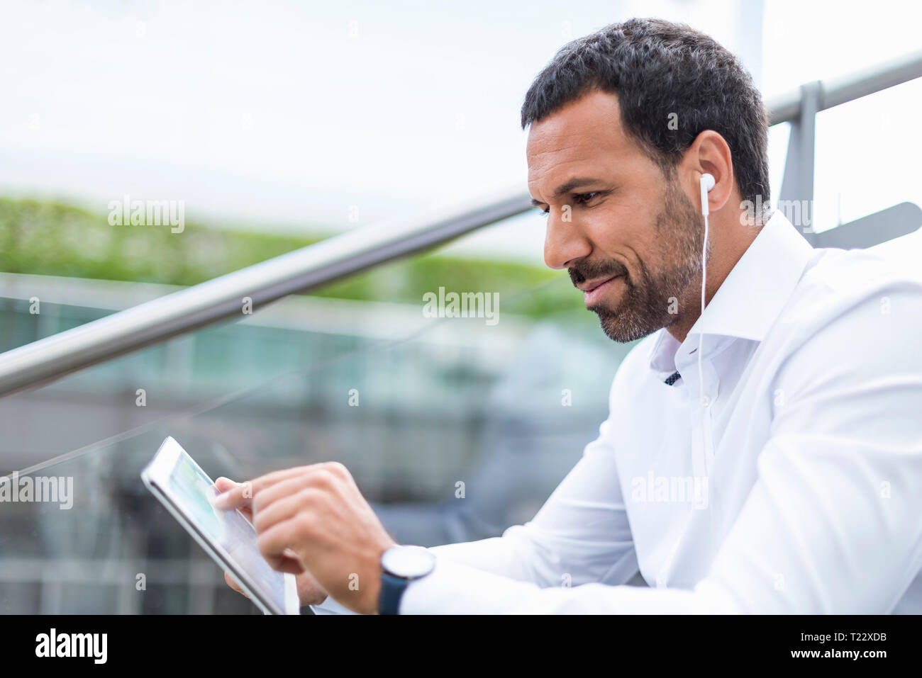 Businessman using tablet, écouteurs Banque D'Images