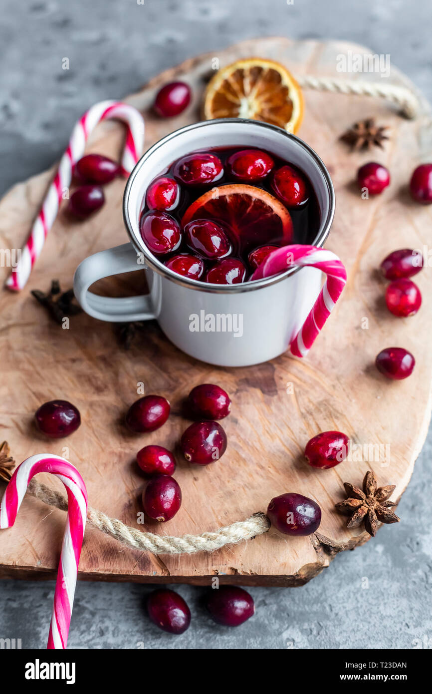 Grande tasse de vin chaud aux canneberges, tranche d'orange, l'anis étoilé et candy cane Banque D'Images