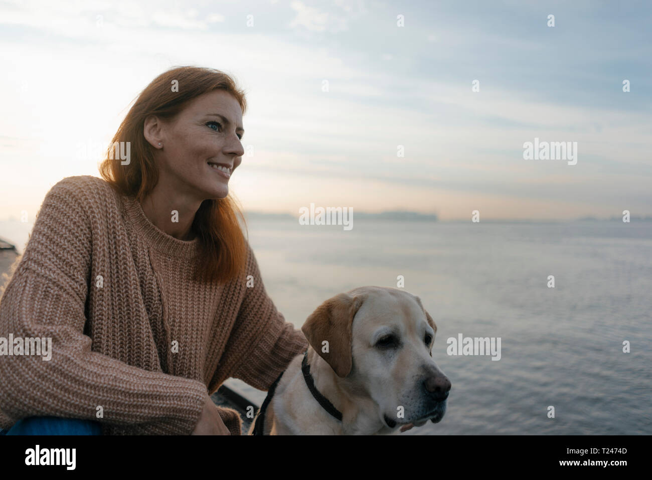 Allemagne, Hambourg, smiling woman with dog à la rive de l'Elbe Banque D'Images