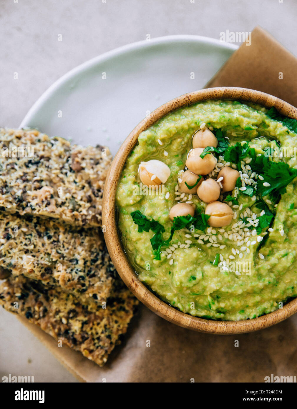 Dans l'hummus pois bol en bois, des biscottes sur la plaque Banque D'Images