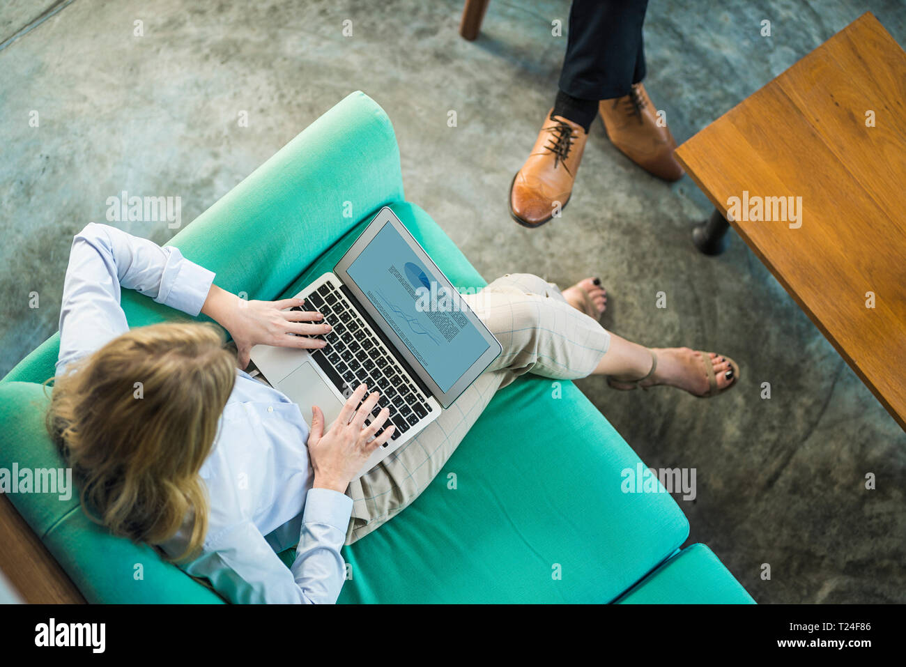 Vue de dessus de businesswoman working on laptop sur la table turquoise en espace de coworking Banque D'Images
