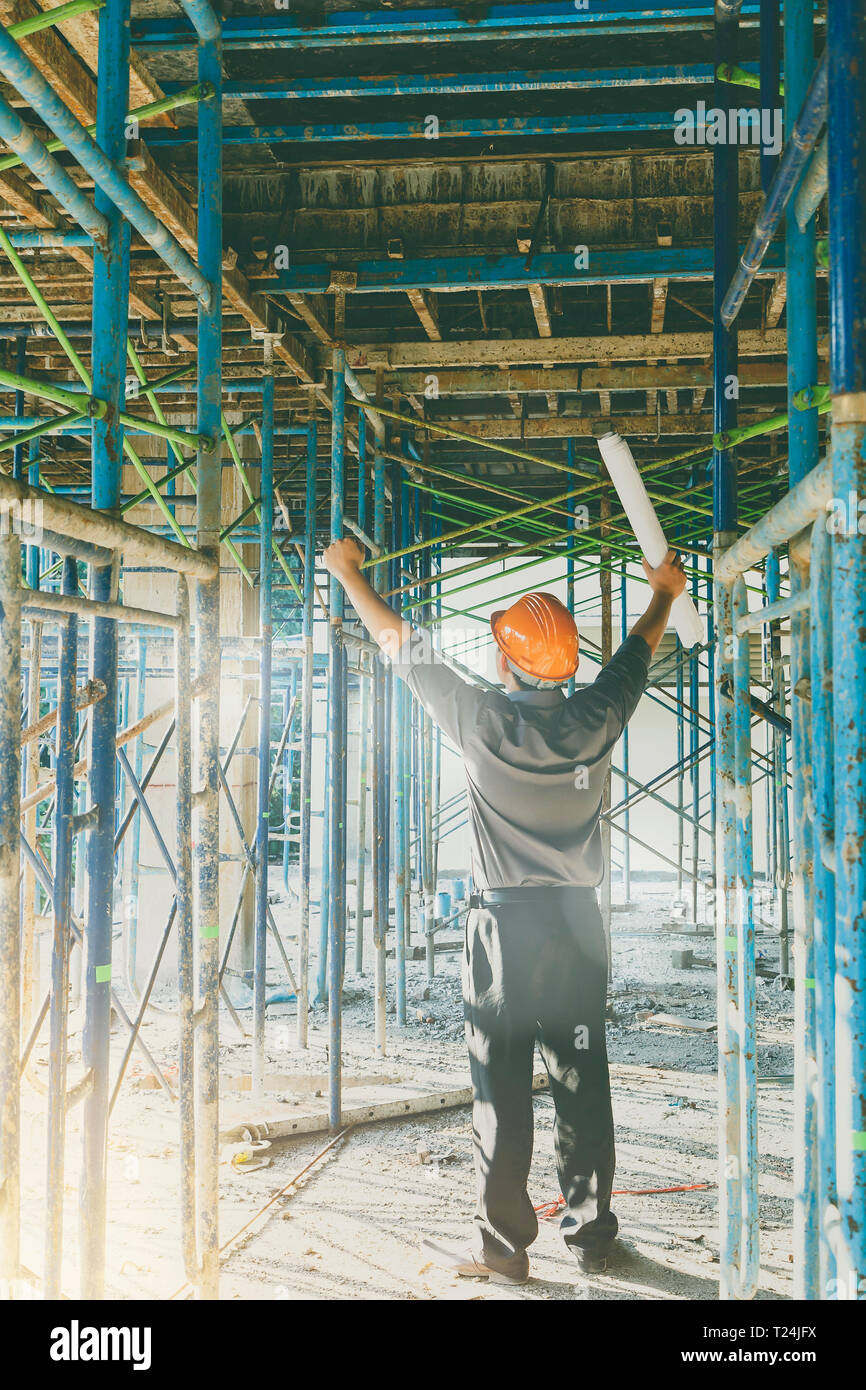 Avec le plan directeur contremaître ou d'ingénieur dans la construction de site. Il pousser ses mains jusqu'à succès sur la construction de site. Banque D'Images