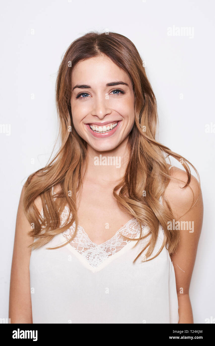 Portrait of laughing young woman wearing white top Banque D'Images