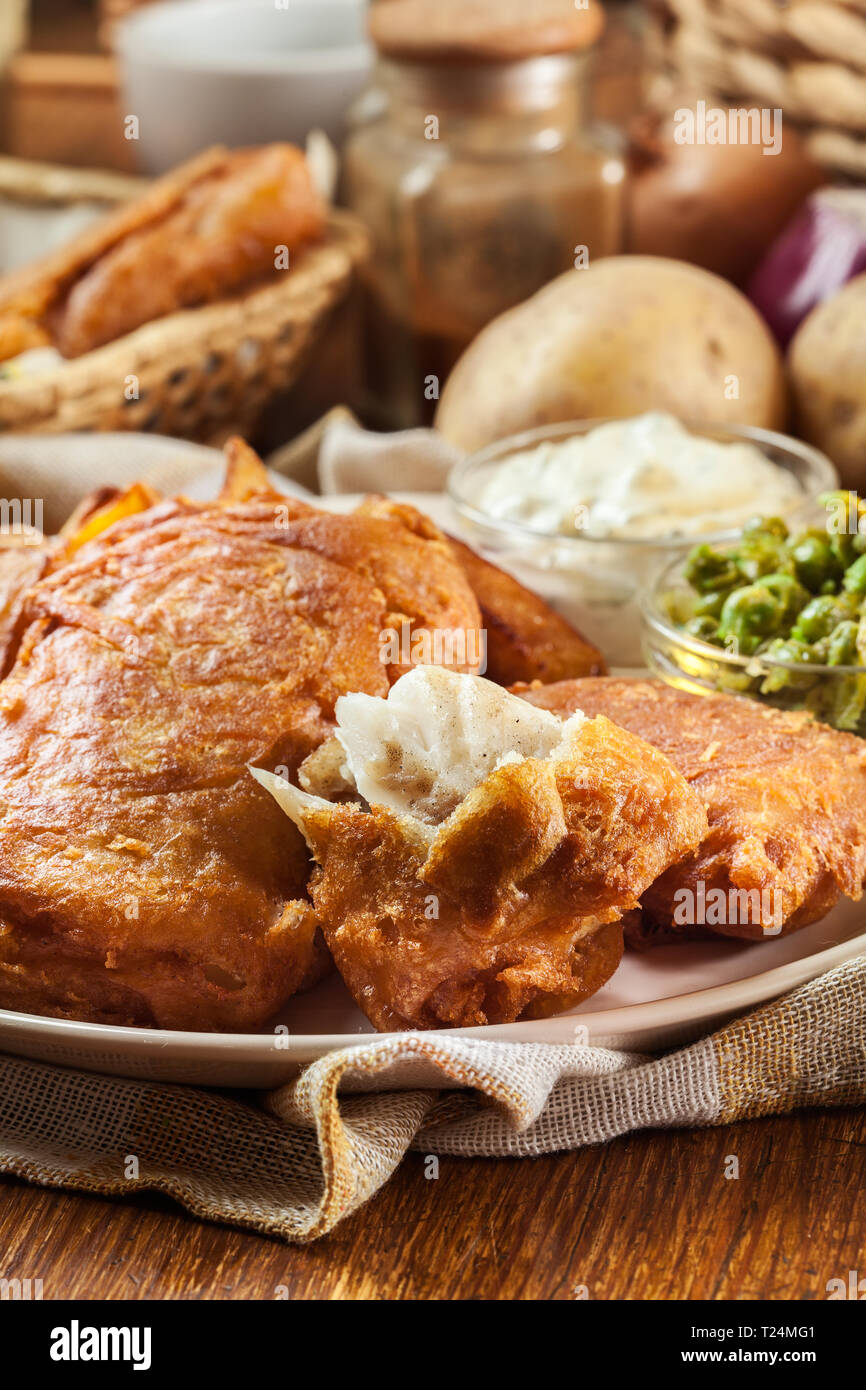 Le poisson dans la pâte traditionnelle de la bière et des frites avec de petits pois et sauce tartare Banque D'Images