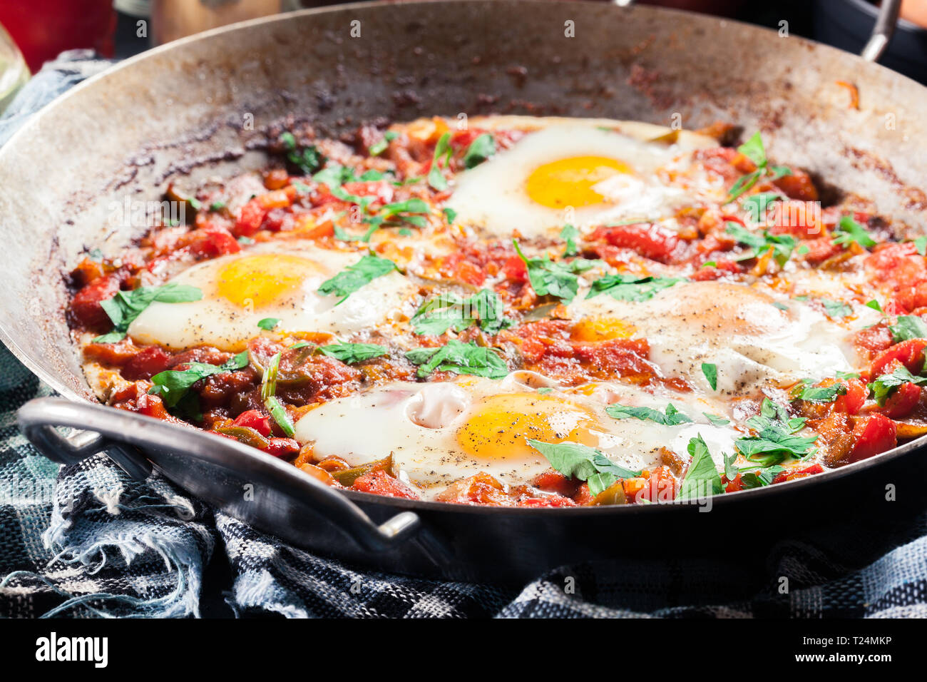 Shakshuka dans une poêle. Plat traditionnel du Moyen-Orient avec les œufs, tomates, poivrons, légumes et fines herbes. Banque D'Images