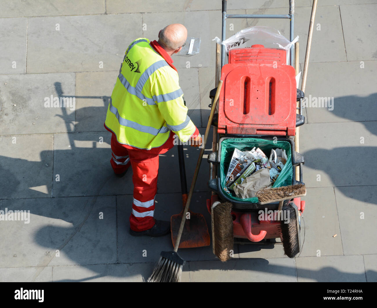 Un balai de route de la City de Londres (Amey), qui travaille dur et méticuleux, lors d'une chaude journée d'été Banque D'Images