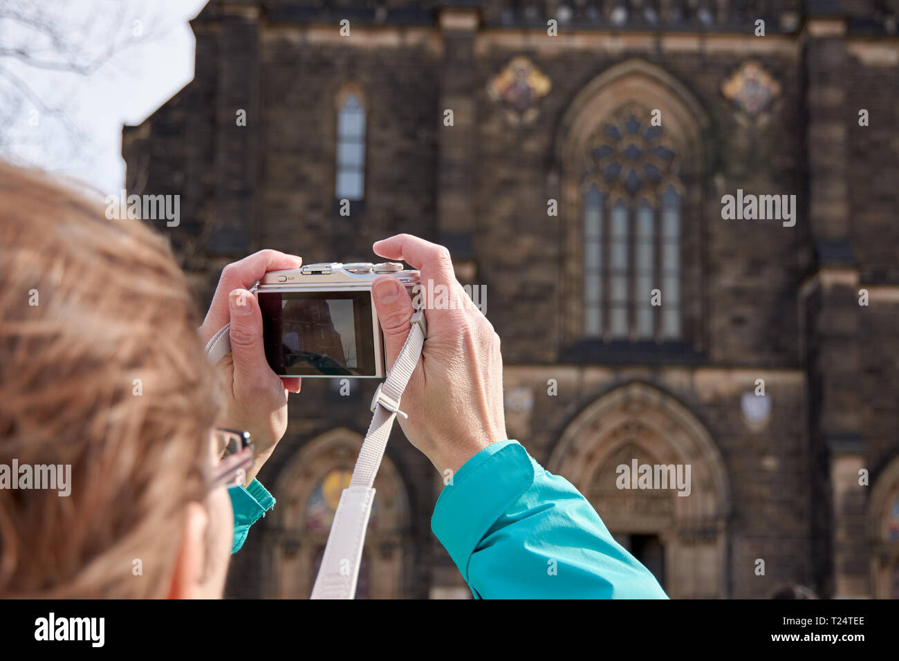 La femme en bleu jacket tenir l'appareil photo et prendre des photos de l'ancien bâtiment Banque D'Images