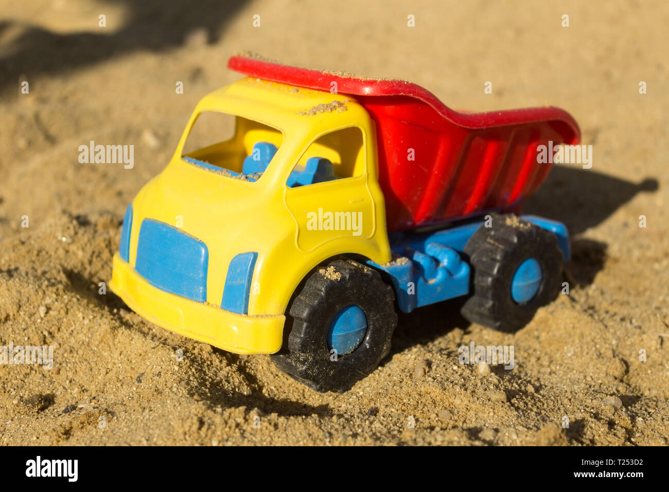 Jaune Rouge Et Bleu Jouet Camion Dans Le Sable Sur La Plage