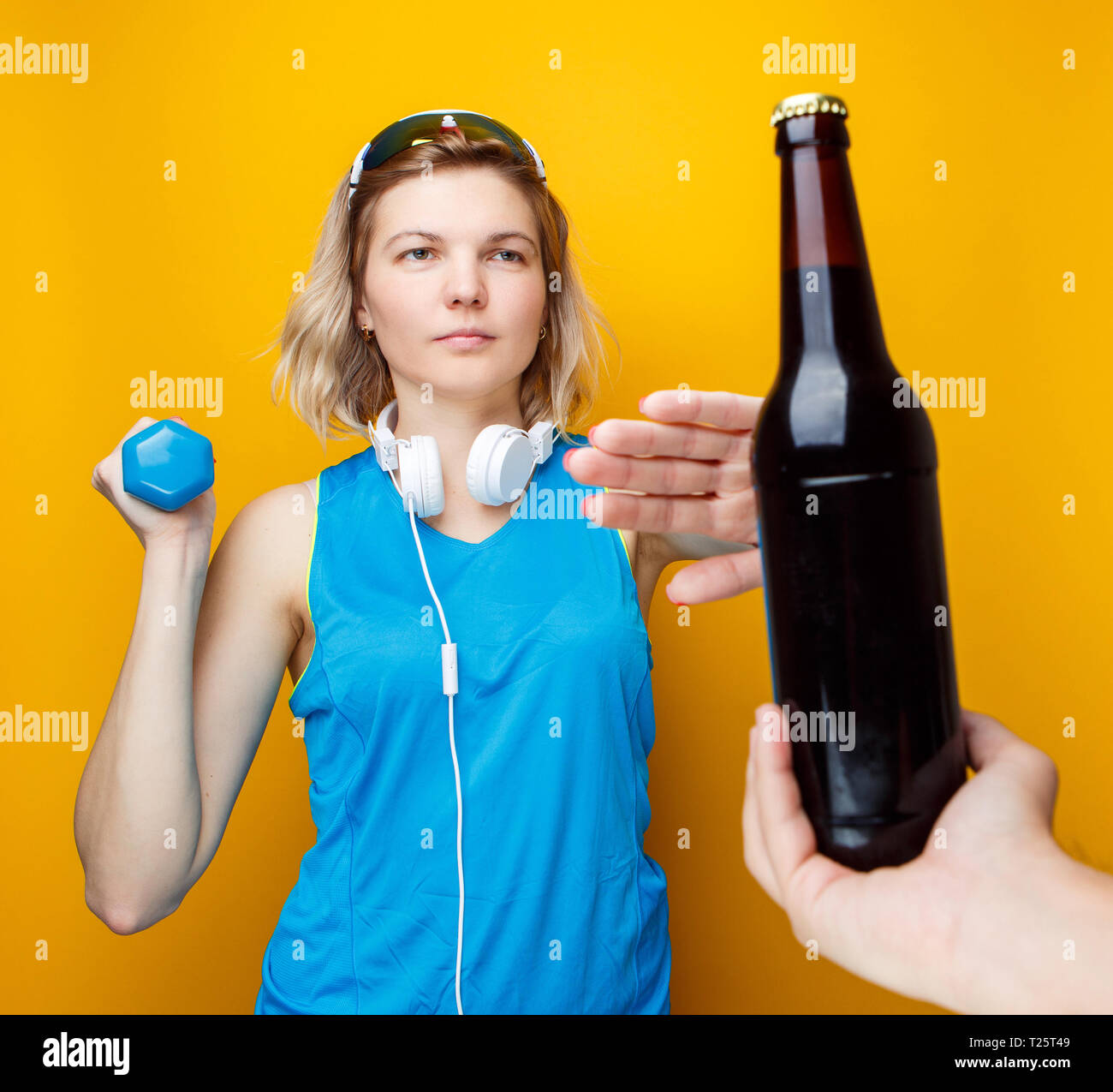 Photo de femme sportive avec haltère refuse de la bouteille de bière en  studio Photo Stock - Alamy