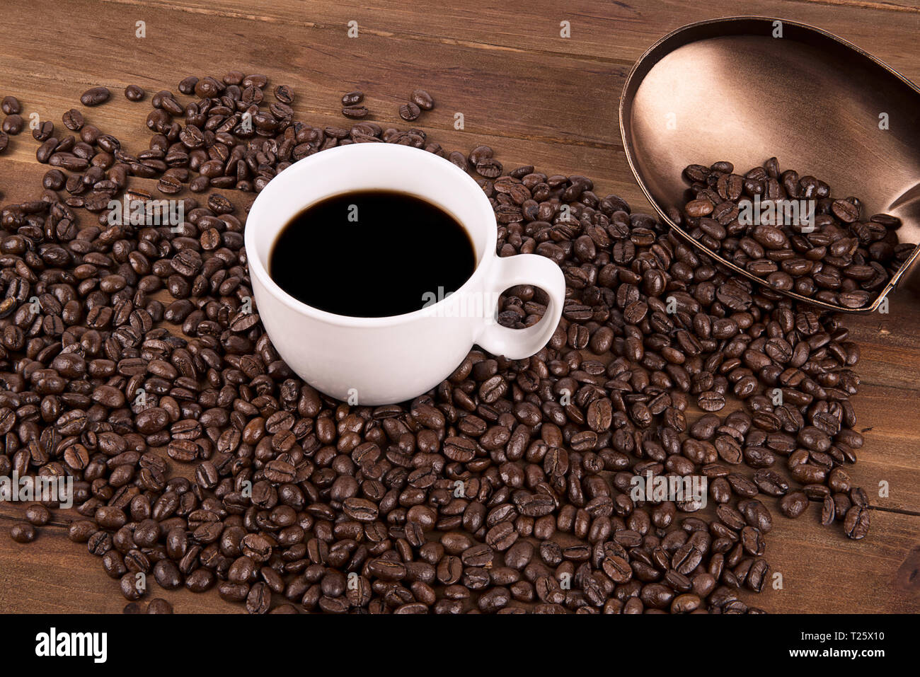 Tasse de café et les grains de café sur le vieux fond de bois. Banque D'Images