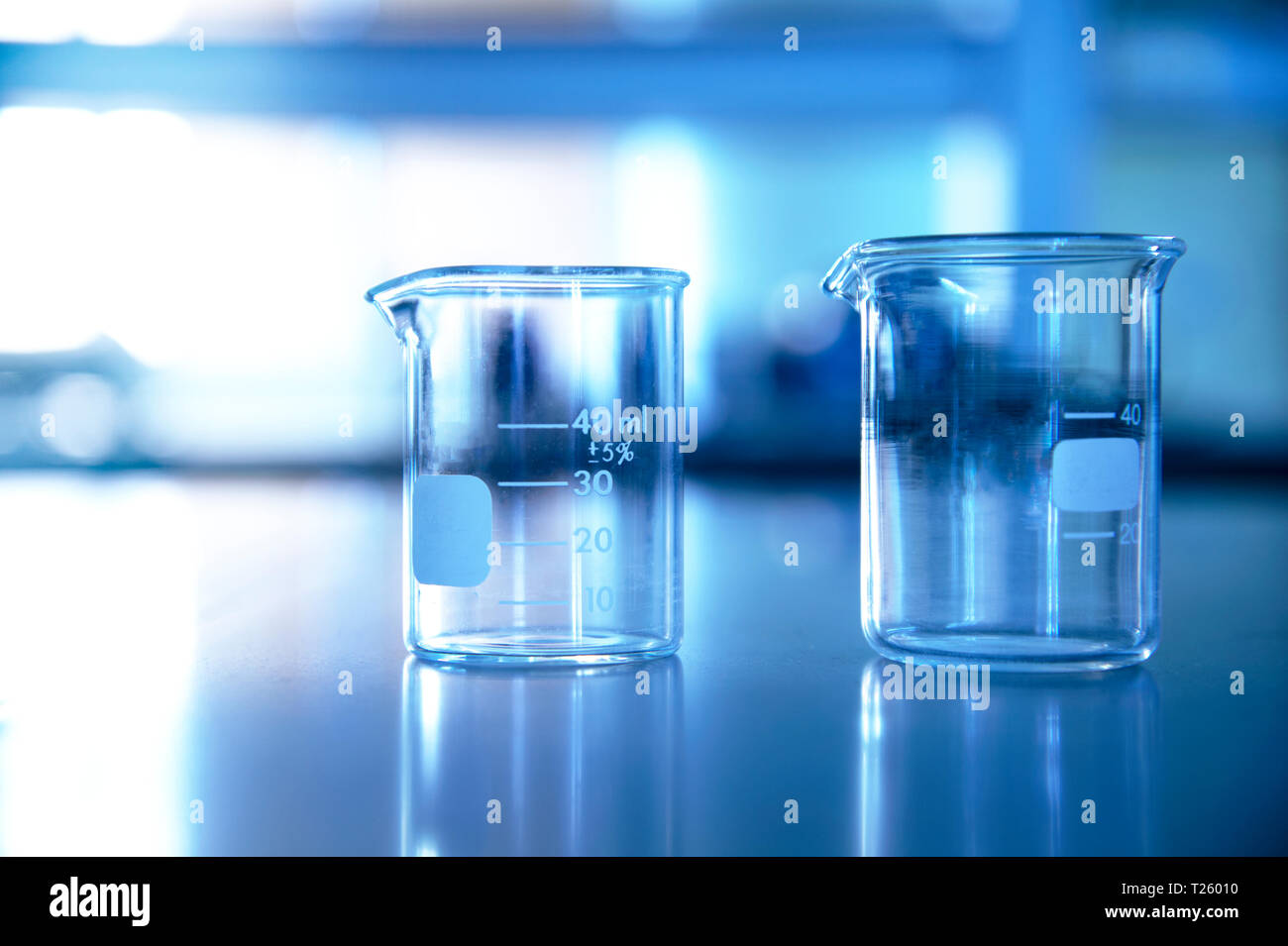 Deux bécher en verre dans la technologie de l'éducation Laboratoire de sciences chimiques fond bleu Banque D'Images