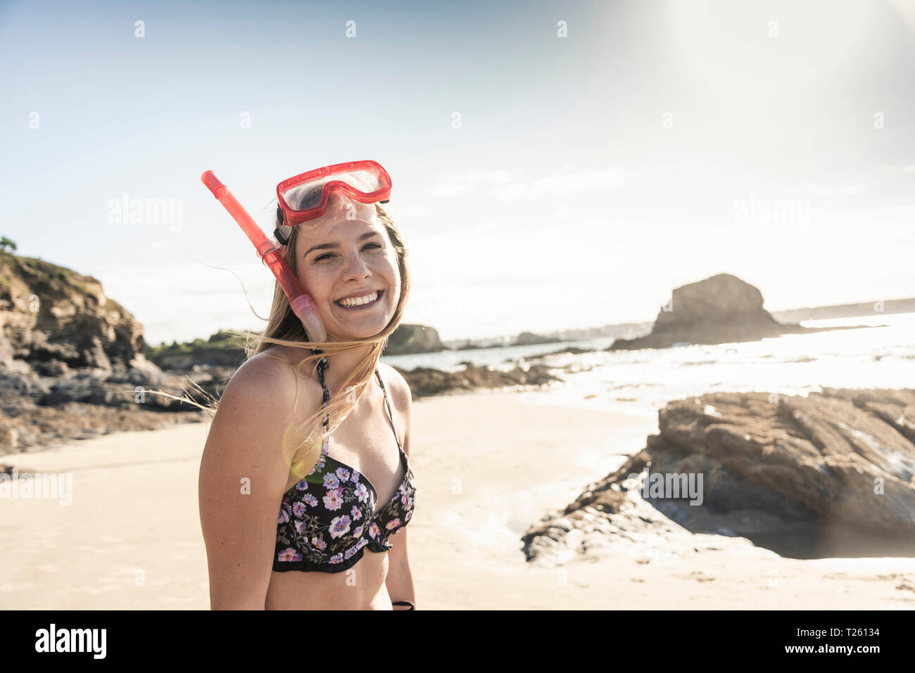 Jeune femme avec des équipements de plongée avec tuba sur la plage, portrait Banque D'Images