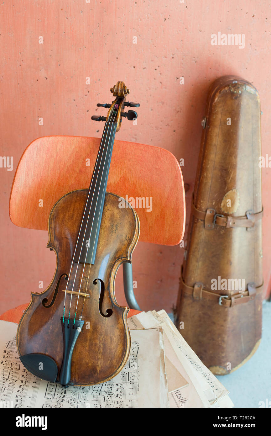 Le violon et la partition de musique sur chaise en bois avec étui à violon dans l'arrière-plan Banque D'Images