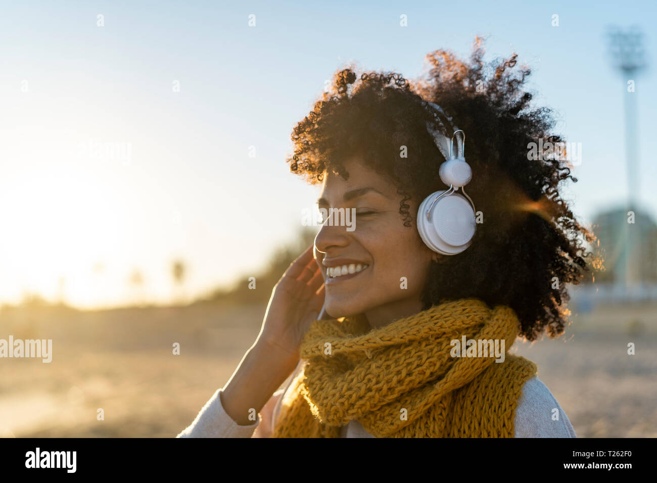 Femme avec écharpe jaune, l'écoute de la musique sur la plage Photo Stock -  Alamy