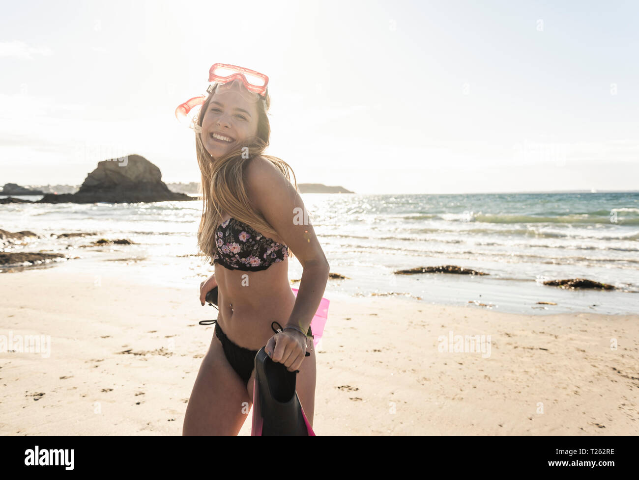 Jeune femme avec des équipements de plongée, s'exécutant sur la plage Banque D'Images