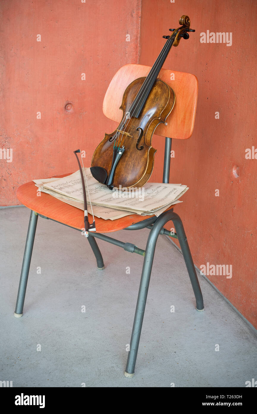 Violon, arc et des feuilles de musique sur chaise en bois Banque D'Images