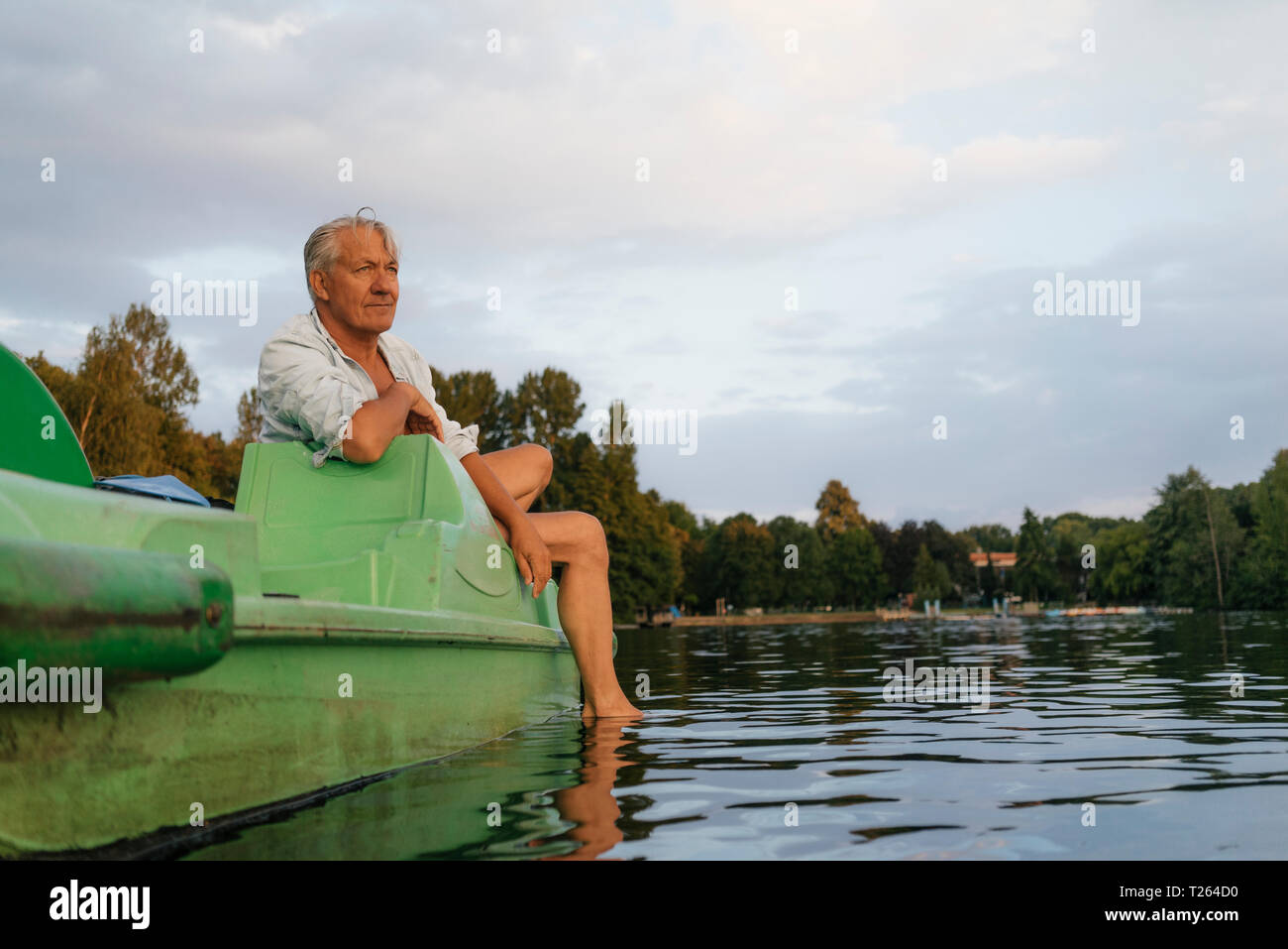 Senior man sitting on rame dans un lac Banque D'Images