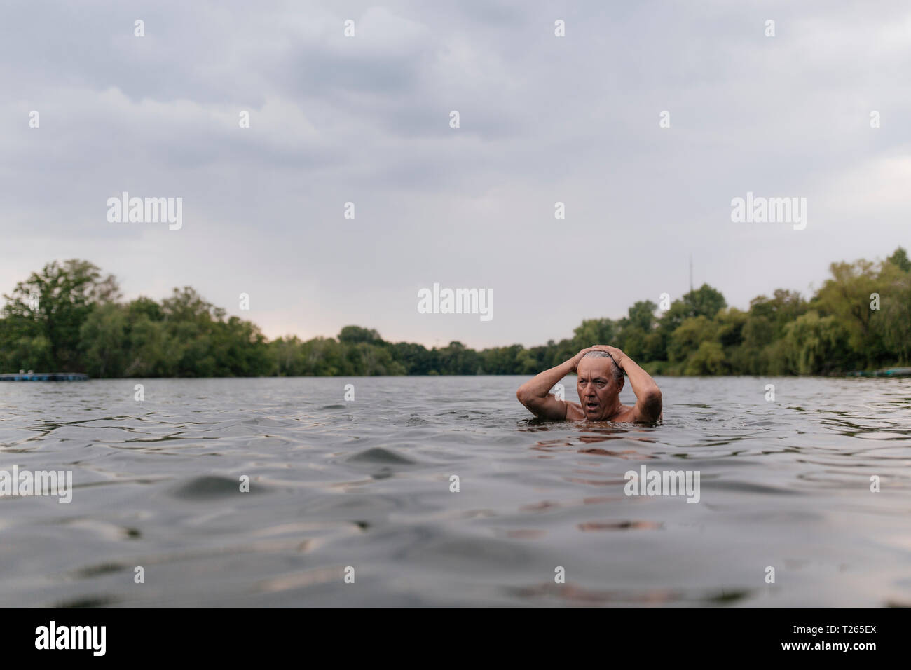 Senior man swimming in a lake Banque D'Images