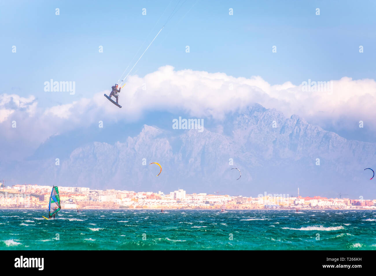 Espagne, Andalousie, Tarifa, les véliplanchistes et kitesurfers sur la mer avec des montagnes du Maroc dans l'arrière-plan Banque D'Images