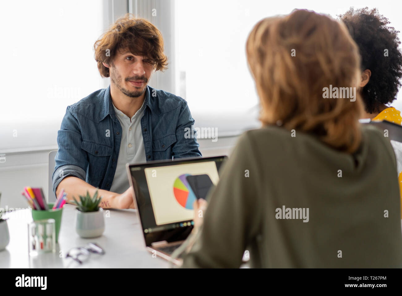 Les jeunes gens d'affaires ayant une réunion à espace de coworking Banque D'Images