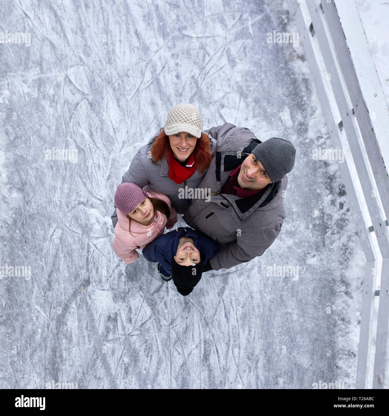 Famille avec deux enfants du patin à glace sur la patinoire Banque D'Images